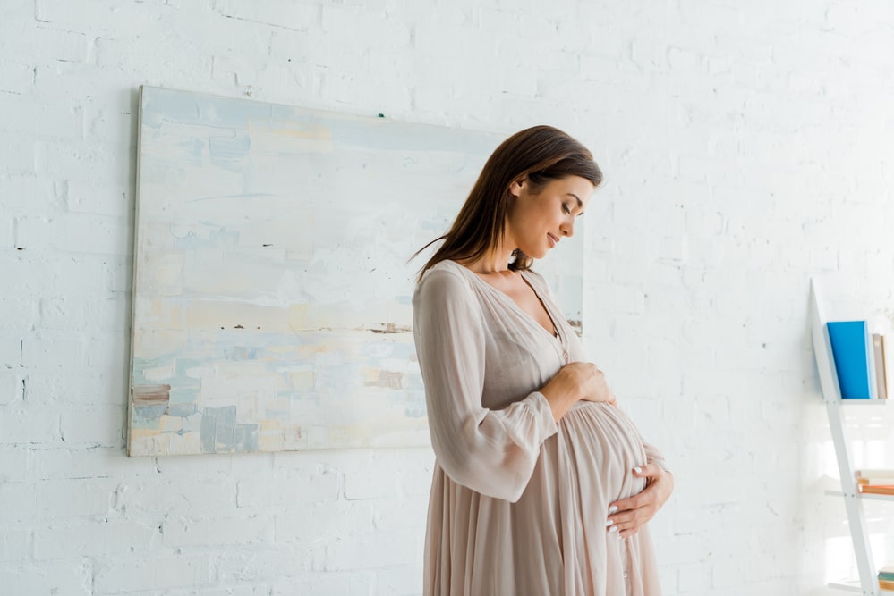 Młoda kobieta w ciąży czekająca na poród, zastanawia się czym jest pęknięcie krocza